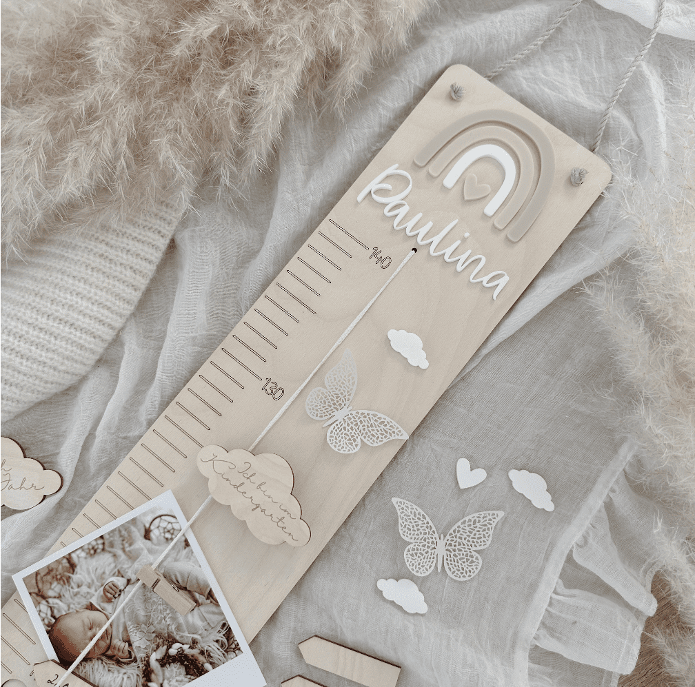 Holzmesslatte mit Regenbogen rosa beige weiß und Name personalisiert mit Meilensteine Schmetterling Wolke und Dino